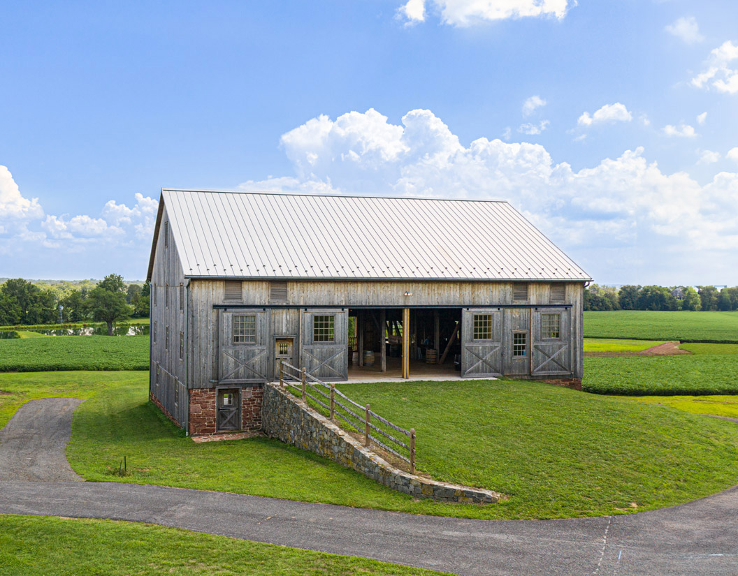 beautiful restored barn with a sloping grassy slope up to the door